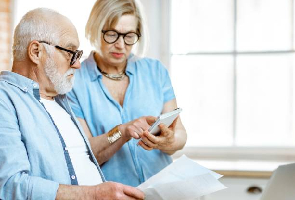 Un homme et une femme regardent des documents et une calculatrice