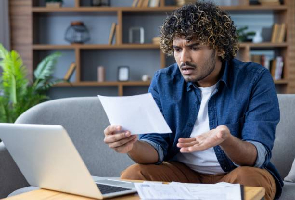 Un homme regarde son ordinateur en s'interrogeant.